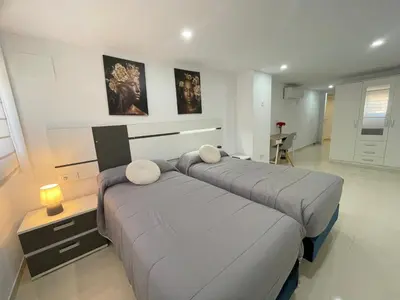 a bedroom with two beds and a table with a lamp at MalvaLindaBeach Preciosa Casa Malvarrosa-Patacona in Valencia