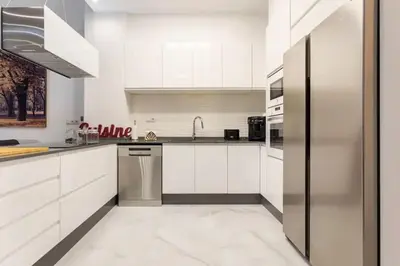 a kitchen with white cabinets and a stainless steel refrigerator at Apartamento Exclusivo en Valencia in Valencia