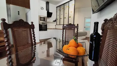 a kitchen with two baskets of oranges and a bottle of wine at Reina in Valencia