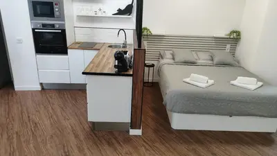 a small bedroom with a bed and a kitchen at Reina in Valencia