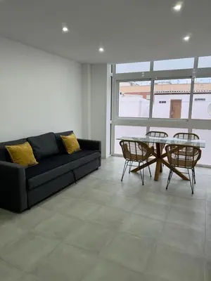 a living room with a couch and a table and chairs at UIM Mediterraneo Cendoya 4 Wifi in Puerto de Sagunto