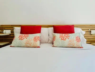 a white bed with red pillows on it at Stylish Apartment with Terrace on the BeachFrom in Valencia