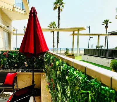 a red umbrella sitting on a balcony with the beach at Stylish Apartment with Terrace on the BeachFrom in Valencia