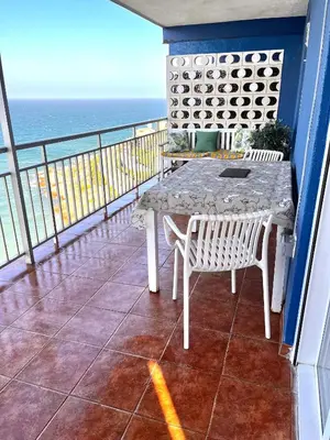 a living room with a table and chairs and the ocean at Ático El Faro Cullera in Faro de Cullera