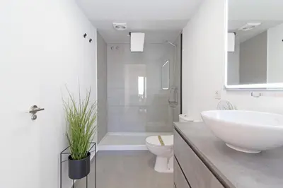 a white bathroom with a sink and a toilet at Global Vacacional, Moderno apartamento con piscina y terraza en la playa de Canet in Canet de Berenguer