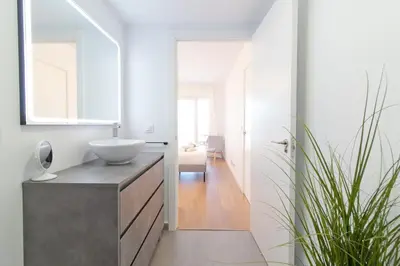 a bathroom with a sink and a mirror at Global Vacacional, Moderno apartamento con piscina y terraza en la playa de Canet in Canet de Berenguer