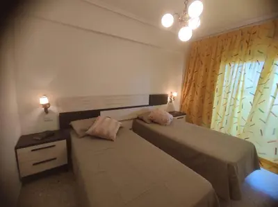 a hotel room with two beds and a window at Amanecer frente al mar in Valencia