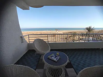 a balcony with a table and chairs and the beach at Amanecer frente al mar in Valencia