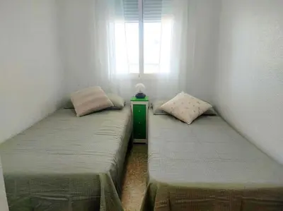 two twin beds in a room with a window at Amanecer frente al mar in Valencia