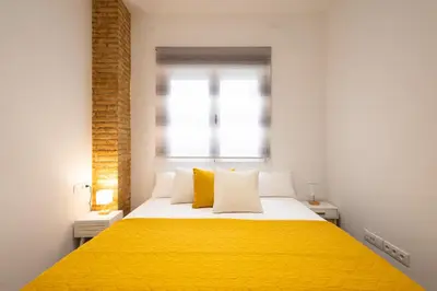 a bedroom with a yellow bed with a window at FLORIT FLATS - The Patraix Apartments in Valencia
