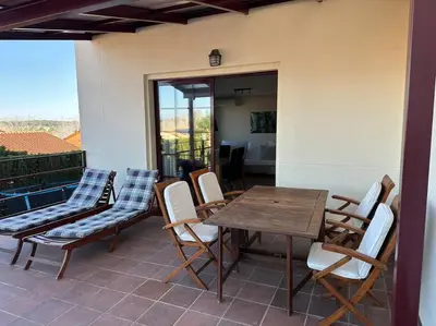 a patio with a wooden table and chairs on a balcony at Oasis en Riba Roja del Turia in Riba-Roja De Turia