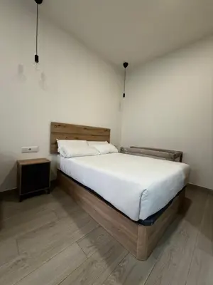 a living room with a table and a kitchen at APARTAMENTOS CIUDAD DE LAS ARTES Y LAS CIENCIAS in Valencia