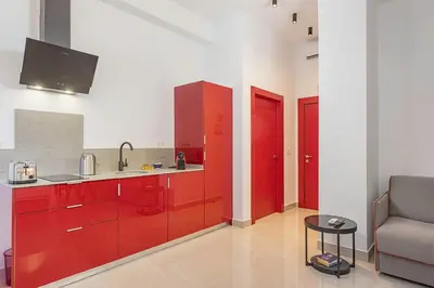 a kitchen with red cabinets and a couch at Gulliver Suites Valencia in Valencia