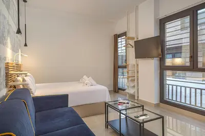 a living room with a couch and a bed at Gulliver Suites Valencia in Valencia