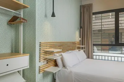 a bedroom with a white bed and a window at Gulliver Suites Valencia in Valencia