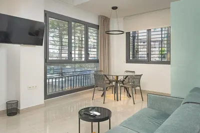 a living room with a couch and a table with chairs at Gulliver Suites Valencia in Valencia