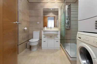 a bathroom with a toilet and a sink and a washing machine at Patacona Mediterranean Beach in Valencia