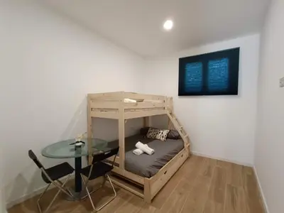a room with a bunk bed and a glass table at Apartamento Disfrutones Valencia in Valencia