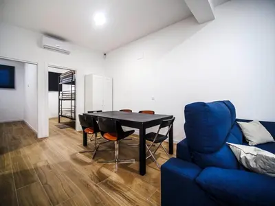 a living room with a table and a blue couch at Apartamento Disfrutones Valencia in Valencia