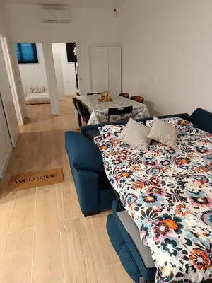 a bedroom with a bed and a blue couch with a floral blanket at Apartamento Disfrutones Valencia in Valencia