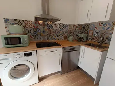 a kitchen with a washing machine and a microwave at Apartamento Disfrutones Valencia in Valencia