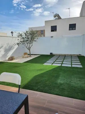 a white building with a green lawn in front of it at the butterfly house in Rafelbuñol