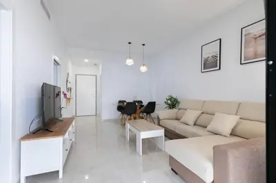 a white living room with a couch and a table at the butterfly house in Rafelbuñol
