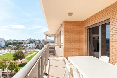a balcony with a table and chairs and a view of the city at Burriana Beach Retreat: Pool & Comfort in Burriana