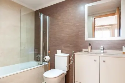 a bathroom with a toilet and a shower and a sink at Burriana Beach Retreat: Pool & Comfort in Burriana