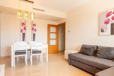 a living room with a table and a couch at Burriana Beach Retreat: Pool & Comfort in Burriana
