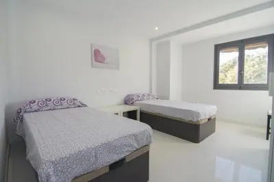 a white room with two beds and a window at Calm Company in Valencia