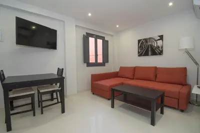 a living room with a red couch and a table at Calm Company in Valencia
