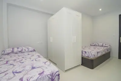 a white room with a bed and a closet at Calm Company in Valencia
