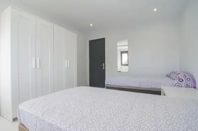 a white bedroom with a bed and a cabinet at Calm Company in Valencia