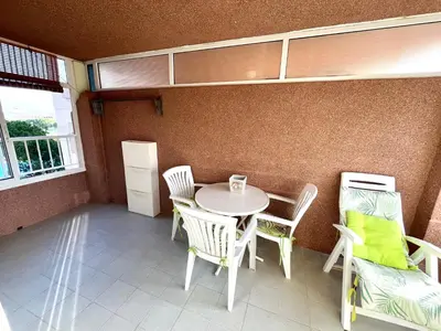 a kitchen with a table and chairs and a refrigerator at Apartamento en la Playa Canet, muy cerca de Valencia in Canet de Berenguer