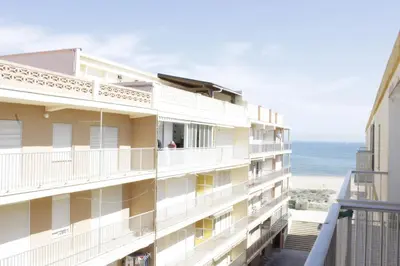 a building with a balcony with the ocean in the background at El Descans Solo Familias Serviplaya in Casas Las Basas