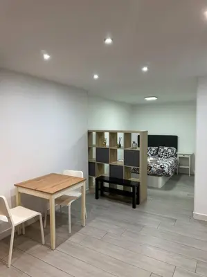 a room with a table and chairs and a bed at Precioso apartamento 2 personas in Valencia