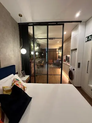 a room with a bed and a living room at Fabulosa vivienda nueva a un paso de Plaza EspañA in Valencia