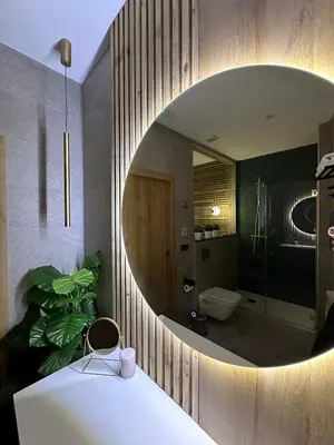 a bathroom with a round mirror and a sink at Fabulosa vivienda nueva a un paso de Plaza EspañA in Valencia