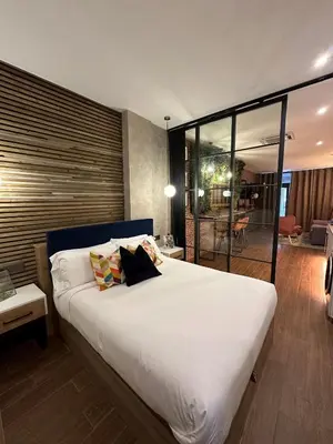 a bedroom with a large white bed and a living room at Fabulosa vivienda nueva a un paso de Plaza EspañA in Valencia
