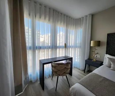 a bedroom with a desk and a bed and a window at MD Pont de Fusta in Valencia