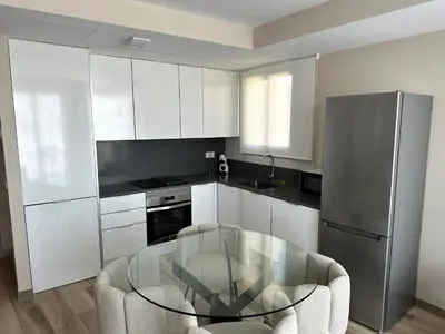 a kitchen with a glass table and a stainless steel refrigerator at MD Pont de Fusta in Valencia
