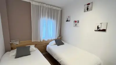 two beds in a room with a window at La Casica de los Abuelos By El Conserje in Pedralba