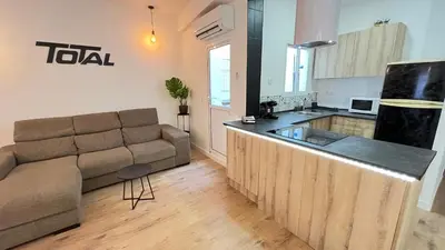 a living room with a couch and a kitchen at La Casica de los Abuelos By El Conserje in Pedralba