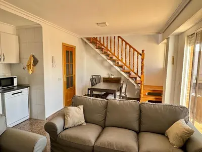 a living room with a couch and a staircase at Your Long Stay Attic Home in Valencia in Valencia