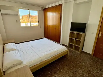 a small bedroom with a bed and a television at Your Long Stay Attic Home in Valencia in Valencia