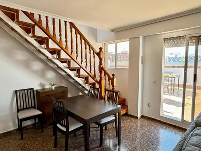 a dining room with a table and chairs and stairs at Your Long Stay Attic Home in Valencia in Valencia