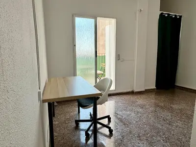 a table and a chair in a room with a window at Your Long Stay Attic Home in Valencia in Valencia