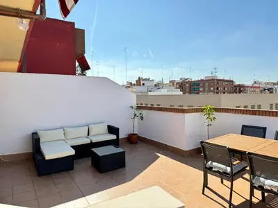 a patio with a couch and a table on a roof at Your Long Stay Attic Home in Valencia in Valencia