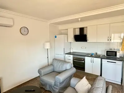 a living room with a couch and a kitchen at Your Long Stay Attic Home in Valencia in Valencia